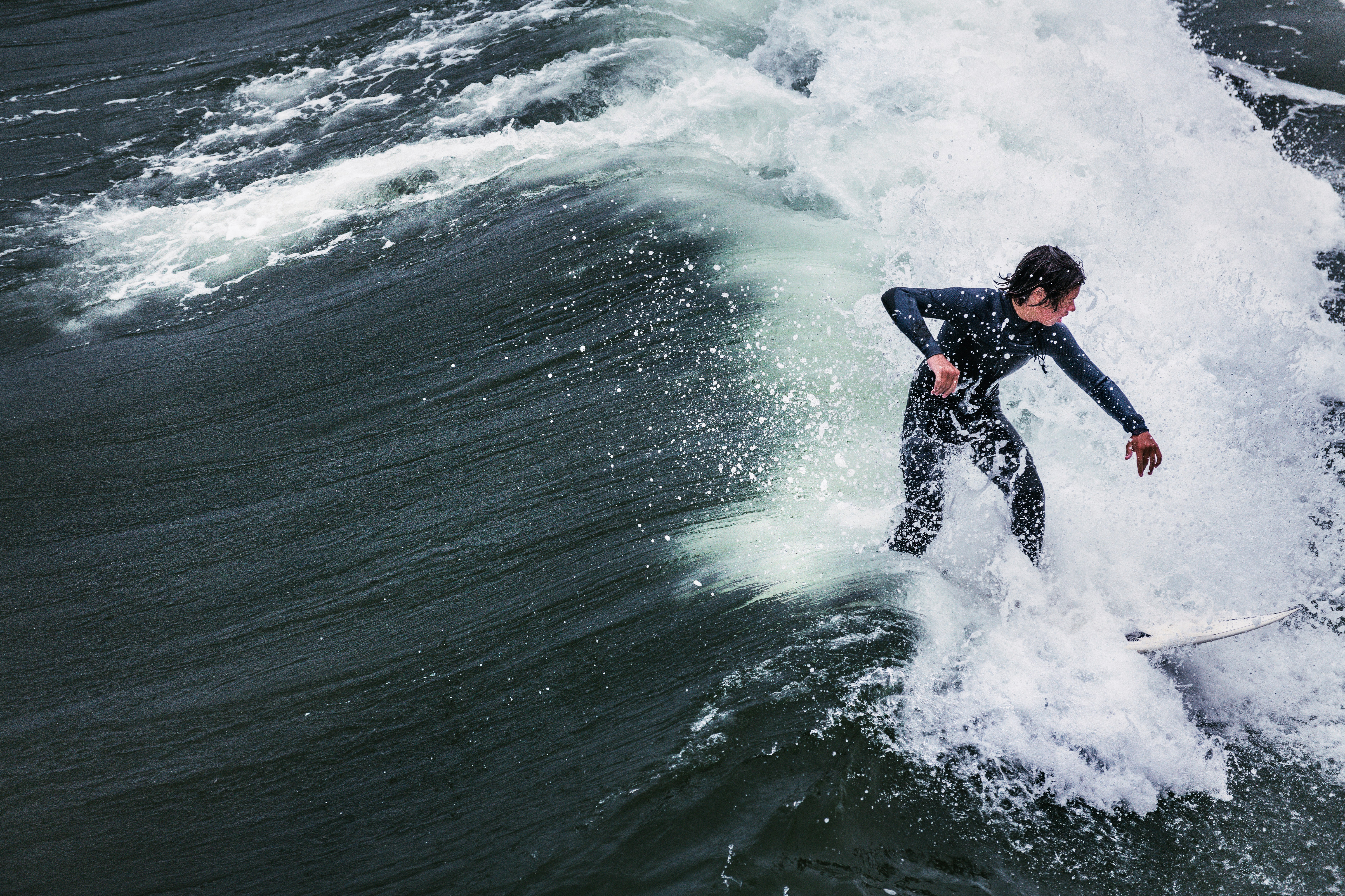 man in black wet suit surfing on sea waves during daytime